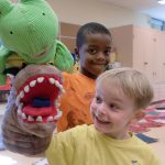 Campers smiling with puppets